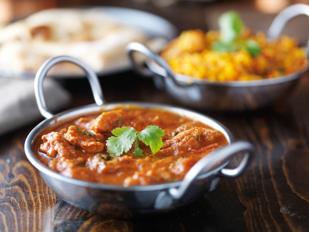 Balti dishes of curry and rice with naan bread