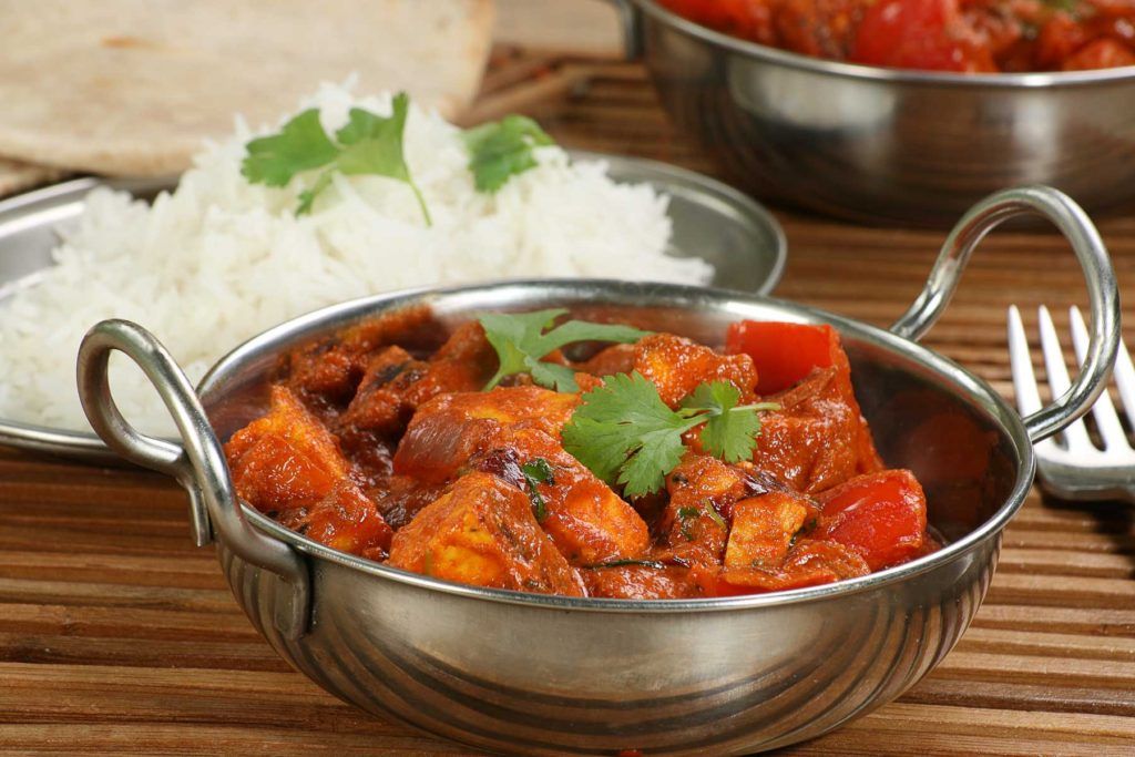 Curry served in a balti dish with rice and naan