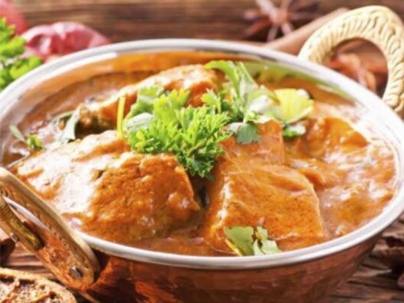 Creamy curry in a copper karahi with coriander